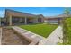 Lush backyard features manicured synthetic lawn, a decorative pergola, and vibrant landscaping at 2518 E Novak Way, Phoenix, AZ 85042