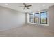 Bright bedroom with large windows offering natural light and a ceiling fan for added comfort at 2518 E Novak Way, Phoenix, AZ 85042