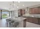 Open kitchen features a large island with bar seating and stainless appliances; the backyard is visible through sliding glass doors at 2518 E Novak Way, Phoenix, AZ 85042
