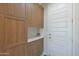 Mud room features built-in wooden cabinets and granite counters; the front door is easily accessible at 2518 E Novak Way, Phoenix, AZ 85042