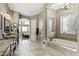 A luxurious bathroom with dual vanities, walk-in shower, a soaking tub, and access to the main bedroom at 27421 N 22Nd Ln, Phoenix, AZ 85085