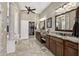 Elegant bathroom featuring dual vanities, granite countertops, tile floors, and walk-in closet access at 27421 N 22Nd Ln, Phoenix, AZ 85085