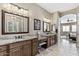 Bathroom featuring granite countertops, dual vanities, tile floors, and access to the main bedroom at 27421 N 22Nd Ln, Phoenix, AZ 85085