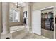 Bathroom featuring a luxurious tub, stone column, and walk-in closet access at 27421 N 22Nd Ln, Phoenix, AZ 85085