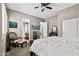 Bright bedroom with a chair, TV, and a view to the bathroom; ceiling fan and neutral color scheme at 27421 N 22Nd Ln, Phoenix, AZ 85085