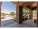 Covered front porch with decorative columns, brick walkway, and desert landscaping at 27421 N 22Nd Ln, Phoenix, AZ 85085