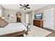Spacious main bedroom featuring ceiling fan, hardwood floors, television, and access to the ensuite at 27421 N 22Nd Ln, Phoenix, AZ 85085