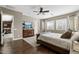 Bright main bedroom with warm-toned walls, ceiling fan, wood floors, dresser and access to ensuite at 27421 N 22Nd Ln, Phoenix, AZ 85085