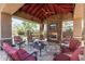 Covered patio featuring stone fireplace, seating area, and television with garden views at 27421 N 22Nd Ln, Phoenix, AZ 85085