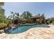 Beautiful pool with a waterfall, surrounded by lush landscaping and a cozy cabana with a fireplace at 27421 N 22Nd Ln, Phoenix, AZ 85085