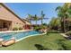 Lush backyard oasis featuring a sparkling pool, tropical landscaping, and a built-in barbecue, ideal for outdoor living at 27421 N 22Nd Ln, Phoenix, AZ 85085