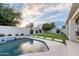 Backyard features pool with water feature, grassy area, and privacy wall with mature landscaping at 2982 S Holguin Way, Chandler, AZ 85286