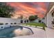 Backyard features pool with water feature, grassy area, and privacy wall with mature landscaping at 2982 S Holguin Way, Chandler, AZ 85286