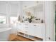 Bright bathroom with white cabinets, dual sinks, and a large mirror with decorative lights at 2982 S Holguin Way, Chandler, AZ 85286