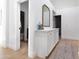 Hallway featuring wood-look flooring and a white cabinet with a mirror, providing a clean and inviting space at 2982 S Holguin Way, Chandler, AZ 85286