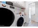 Modern laundry room featuring front load washer and dryer, cabinets and neutral colored tile at 2982 S Holguin Way, Chandler, AZ 85286