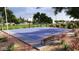 Community basketball court surrounded by lush trees and greenery, featuring a new surface and well-maintained landscaping at 3344 S Lotus Ave, Mesa, AZ 85212