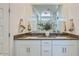 Modern bathroom featuring double sinks, granite countertops, white cabinetry, and decorative vase with botanical accents at 3344 S Lotus Ave, Mesa, AZ 85212