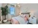 Bedroom with neutral decor, large window, lush houseplant, woven headboard, and plush bedding at 3344 S Lotus Ave, Mesa, AZ 85212
