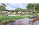 Common community lawn featuring benches surrounded by lush trees, colorful flower beds, and manicured landscaping at 3344 S Lotus Ave, Mesa, AZ 85212