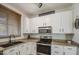 Bright kitchen showcasing stainless steel appliances, granite countertops, and white cabinetry at 3893 E Gideon Way, Gilbert, AZ 85296