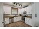 Bright kitchen with white cabinets, stainless steel appliances, granite counters and wood-look flooring at 3893 E Gideon Way, Gilbert, AZ 85296