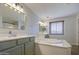 Large main bathroom featuring a soaking tub, double sinks, and a glass shower at 3893 E Gideon Way, Gilbert, AZ 85296