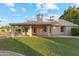 Backyard featuring a covered patio, lush grass, and mature landscaping at 4220 E San Angelo Ave, Gilbert, AZ 85234