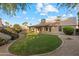 Expansive backyard featuring lush green grass, mature landscaping, and a covered patio at 4220 E San Angelo Ave, Gilbert, AZ 85234