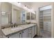 Bathroom featuring a double vanity with granite counters and a walk-in closet at 4220 E San Angelo Ave, Gilbert, AZ 85234