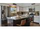 Well-lit kitchen features granite countertops, stainless steel appliances and a central island with seating at 4220 E San Angelo Ave, Gilbert, AZ 85234