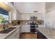 Bright kitchen featuring white cabinets, stainless steel appliances, and a tile backsplash at 4220 E San Angelo Ave, Gilbert, AZ 85234
