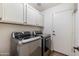 Laundry room featuring modern washer and dryer, white cabinets, and convenient access to the door at 4220 E San Angelo Ave, Gilbert, AZ 85234