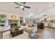 Open-concept living room with a fireplace, kitchen island, and stylish furniture at 4220 E San Angelo Ave, Gilbert, AZ 85234