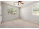 Bedroom with neutral colored walls, carpet, ceiling fan, and bright windows at 4258 E Lexington Ave, Gilbert, AZ 85234