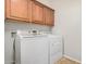 Bright laundry room with upper cabinets and modern, white front load washer and dryer at 4258 E Lexington Ave, Gilbert, AZ 85234