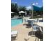 Community pool area featuring mature trees, desert landscaping, lounge chairs, shade canopies, tables, and chairs at 4490 S Montana Dr, Chandler, AZ 85248
