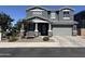 Charming gray two-story home featuring stone accents, a well-manicured yard, and an attached two-car garage at 4490 S Montana Dr, Chandler, AZ 85248