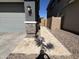 Side view of a gray two-story home with stone accents and a paved walkway leading to a wooden gate at 4490 S Montana Dr, Chandler, AZ 85248