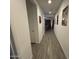 Bright hallway with wood-look tile flooring and decorative wall art leading to the living area at 4490 S Montana Dr, Chandler, AZ 85248