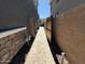 View of the tiled walkway with desert landscaping between homes and gate access at 4490 S Montana Dr, Chandler, AZ 85248