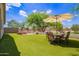 Wide backyard featuring artificial turf, a patio set, and a brick fire pit at 4518 W Carson Rd, Laveen, AZ 85339