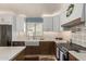 Well-lit kitchen featuring white upper cabinets, brown lower cabinets, and stainless steel appliances at 4518 W Carson Rd, Laveen, AZ 85339