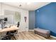 This is an office with a wood desk, computer and chair along with a blue accent wall at 4518 W Carson Rd, Laveen, AZ 85339