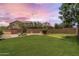 Backyard featuring a putting green, mature trees, green grass, and a play structure at 6299 S Roanoke St, Gilbert, AZ 85298