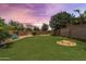 Large backyard features a built-in fire pit and an artificial putting green for outdoor entertainment at 6299 S Roanoke St, Gilbert, AZ 85298