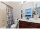 Bright bathroom featuring a shower-tub combo with modern fixtures and a cherry-wood vanity at 6299 S Roanoke St, Gilbert, AZ 85298