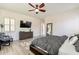 Bright bedroom with wood-look floors, ceiling fan, and large dresser with television, creating a relaxing atmosphere at 6299 S Roanoke St, Gilbert, AZ 85298