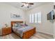 Comfortable bedroom featuring a wood-look floor, ceiling fan, and window with plantation shutters at 6299 S Roanoke St, Gilbert, AZ 85298
