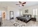 Bright bedroom features wood-look flooring, a full-length mirror, and a comfortable bed with neutral linens at 6299 S Roanoke St, Gilbert, AZ 85298